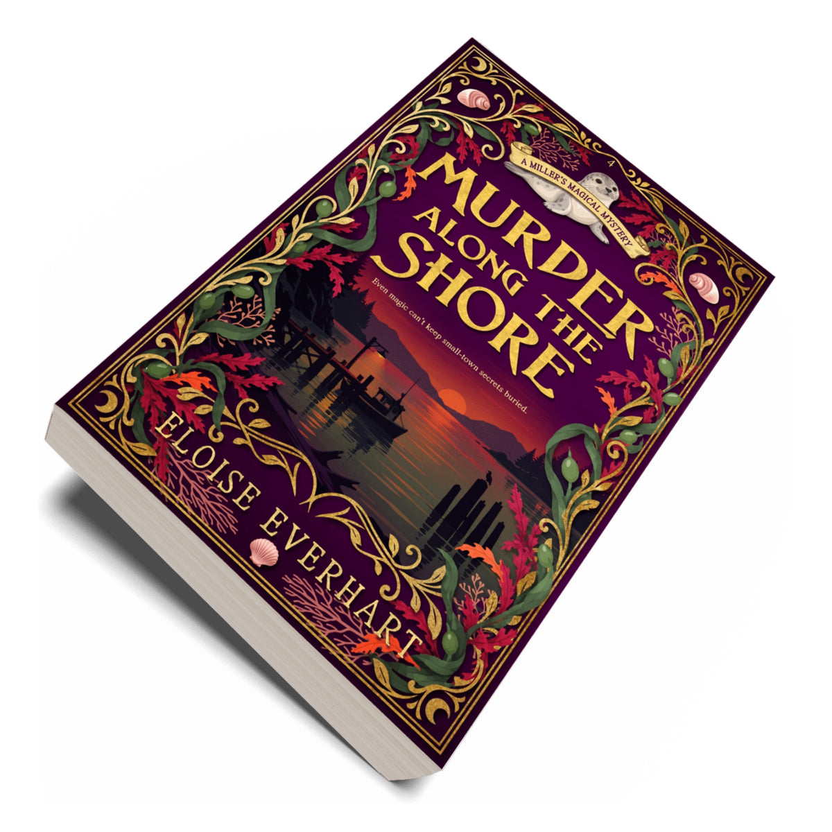 A hardcover book titled 'Murder Along the Shore' by Eloise Everhart, shown at an angle on a white background. The cover features a dark purple background with an ornate border of red, green, and gold foliage, and a sunset scene of a pier in the center.